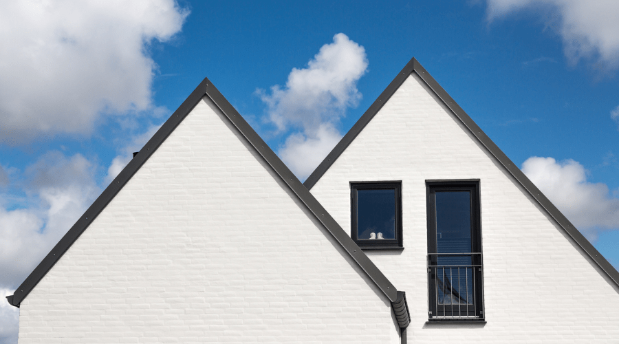 Gable roof with blue sky and clouds behind it