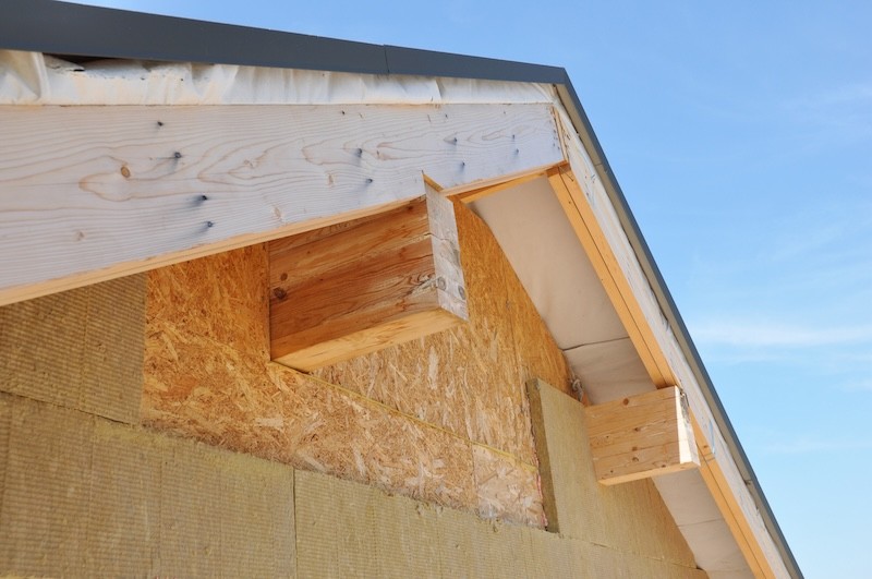 Insulating with Mineral Rock Wool Attic Roof Outdoors. Close up on exterior insulation layers of mineral wool insulation, house roof insulation